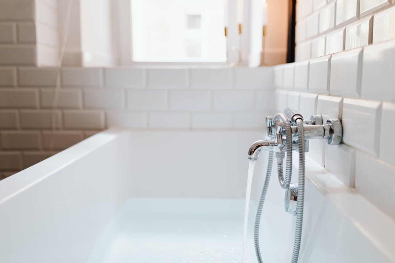 our-services-2 Stylish ceramic bathtub with modern stainless steel faucet in a sunlit bathroom.